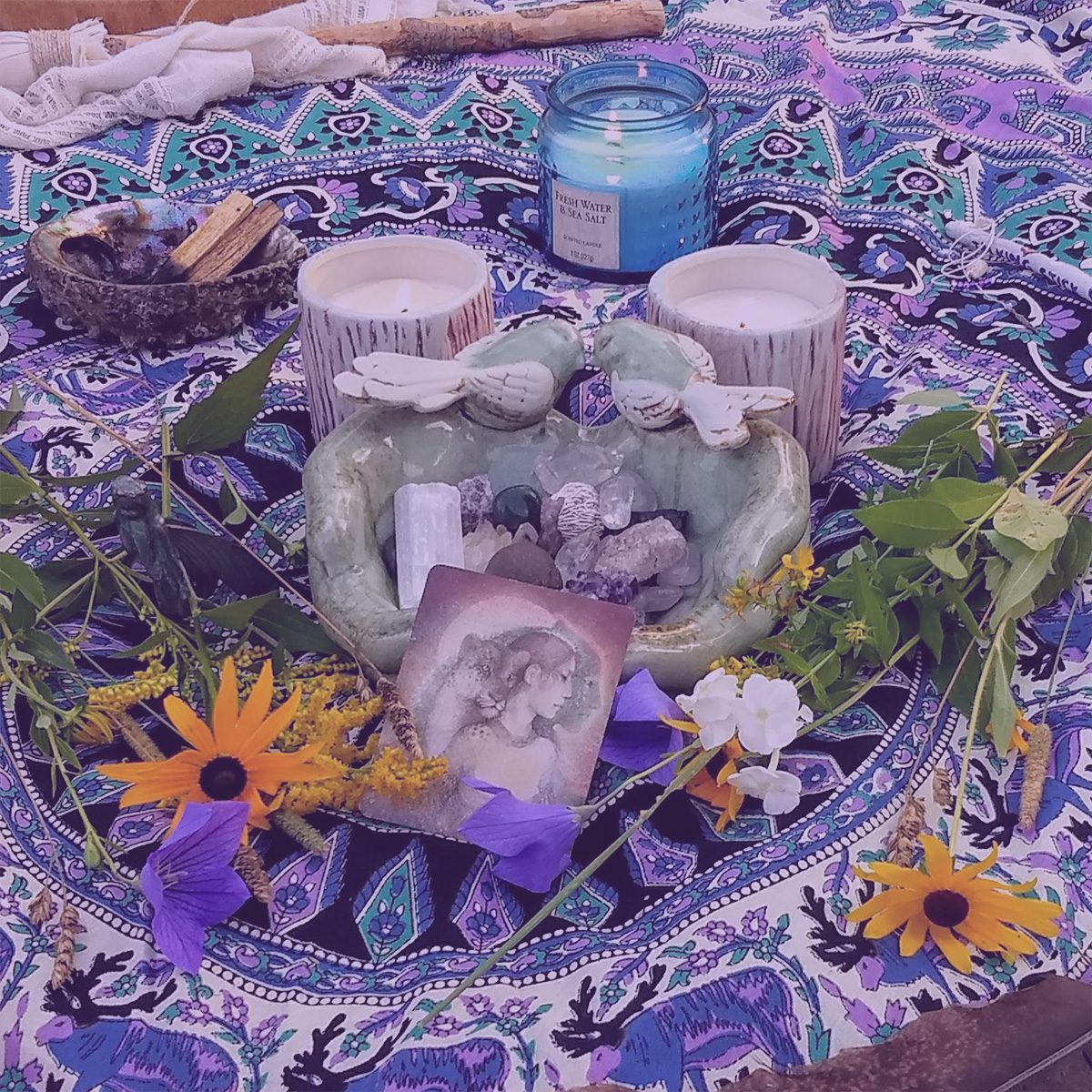 Ritual alter with purple flowers and white candles